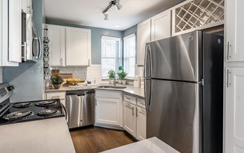 A modern kitchen with a stainless steel refrigerator and white cabinets